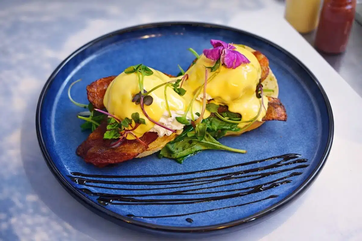 Eggs Benedict dish on a blue plate at Kacks Cafe.
