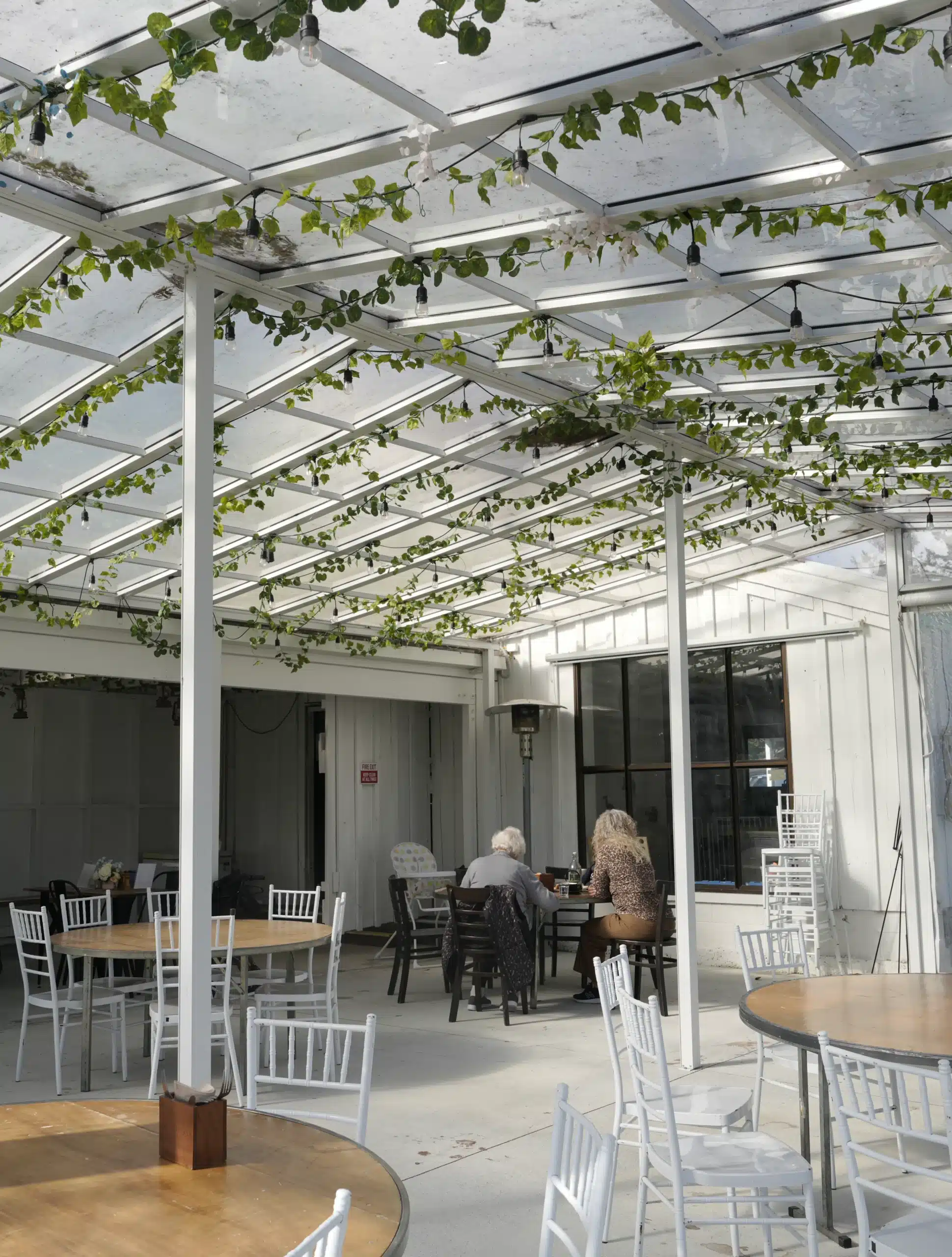 Outdoor cafe seating area with pergola and greenery, Kacks Cafe Clevedon.